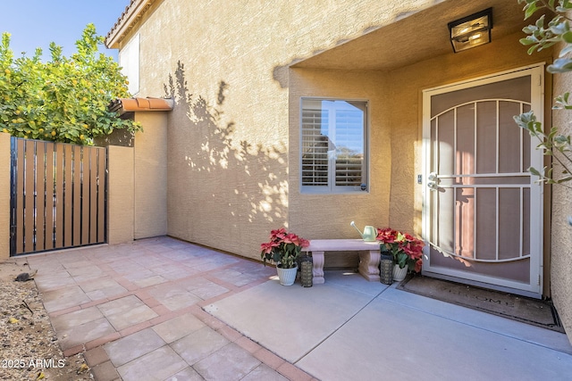 view of exterior entry with a patio area