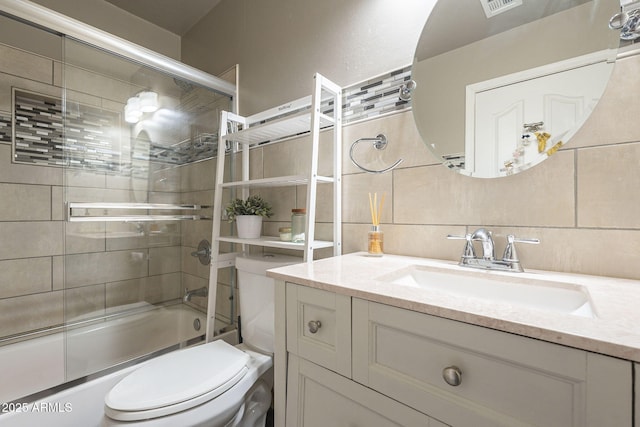 full bathroom with toilet, combined bath / shower with glass door, and vanity