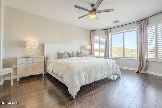 bedroom with ceiling fan, multiple windows, and dark hardwood / wood-style floors