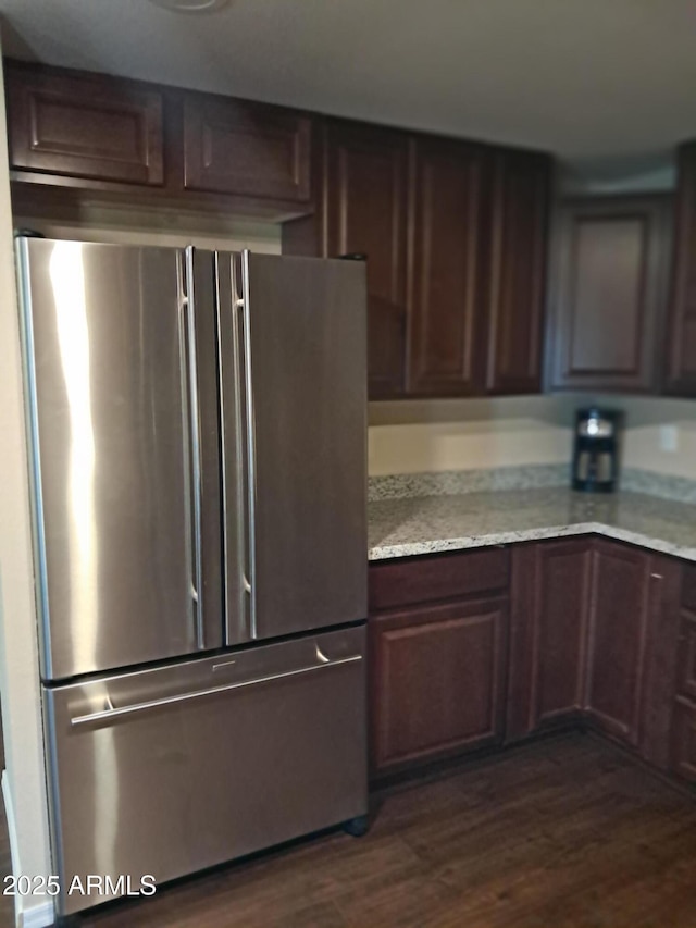 kitchen featuring stainless steel refrigerator, dark brown cabinets, and dark hardwood / wood-style floors