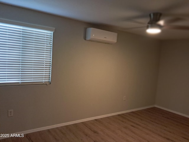 unfurnished room featuring ceiling fan, a wall mounted air conditioner, and wood-type flooring