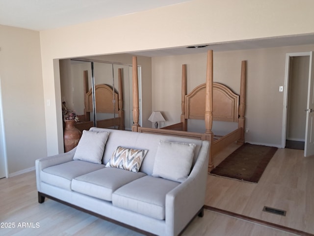 bedroom with light wood-type flooring and a closet