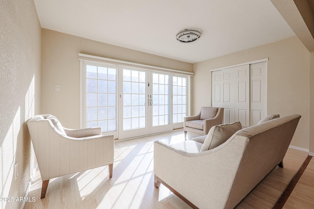 living area featuring light hardwood / wood-style flooring and french doors