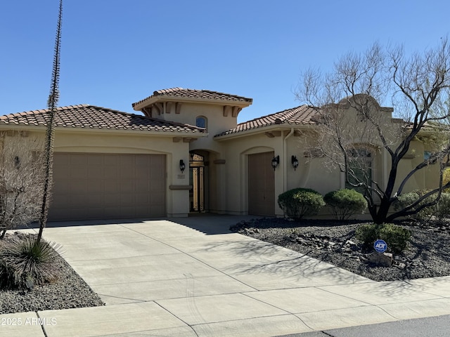 mediterranean / spanish-style home featuring an attached garage, stucco siding, a tile roof, and driveway