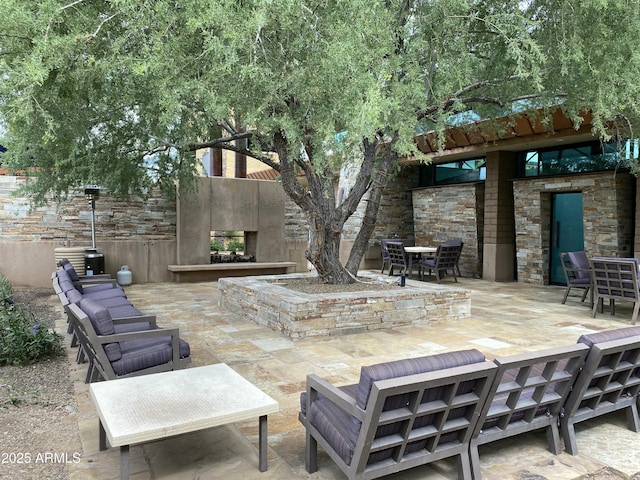view of patio / terrace with a multi sided fireplace and outdoor dining space