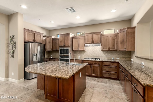 kitchen featuring stainless steel appliances, a sink, light stone counters, backsplash, and recessed lighting