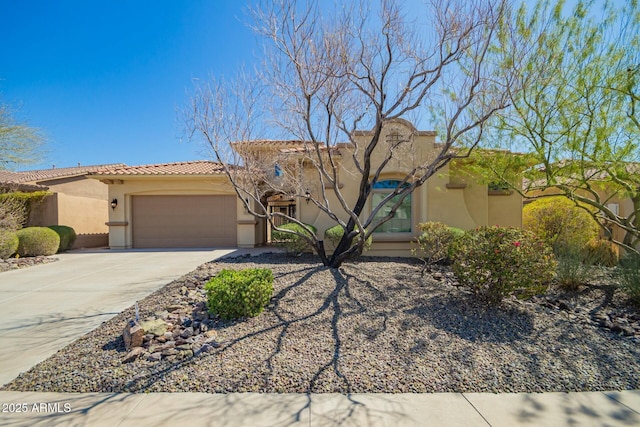 view of front of home with stucco siding, a garage, driveway, and a tiled roof