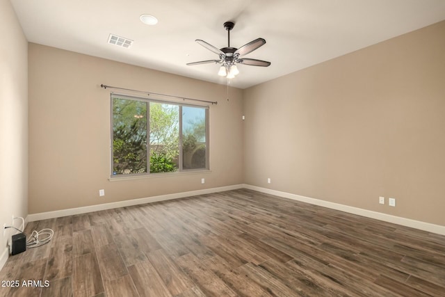 unfurnished room with wood finished floors, a ceiling fan, and baseboards