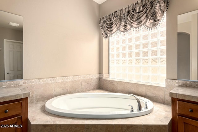 full bath featuring vanity and a garden tub