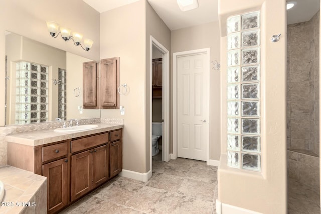 full bath featuring walk in shower, vanity, toilet, baseboards, and a tub to relax in