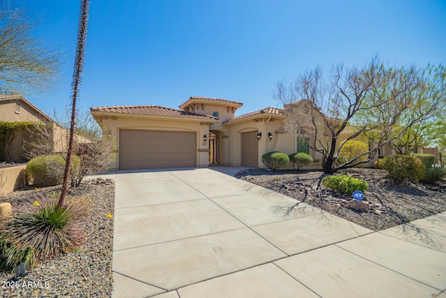 mediterranean / spanish house with an attached garage, stucco siding, concrete driveway, and a tiled roof