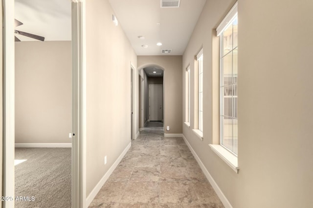 hallway with baseboards and stone finish flooring