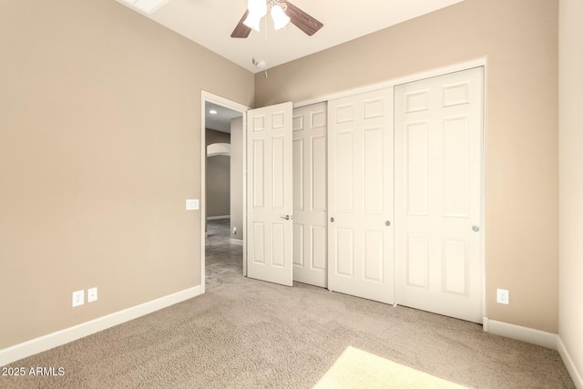 unfurnished bedroom with carpet, baseboards, a closet, and ceiling fan