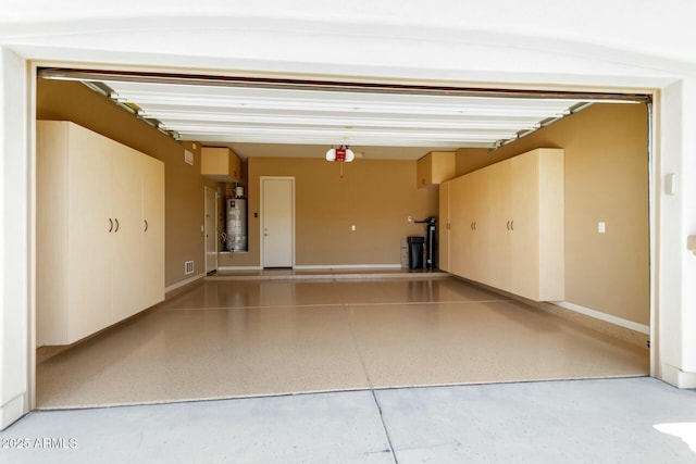 garage featuring strapped water heater, a garage door opener, and baseboards