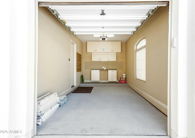 garage featuring a garage door opener and baseboards