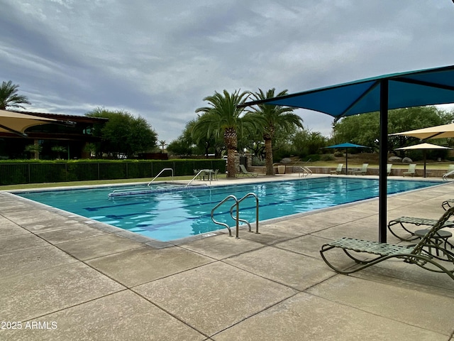 community pool featuring a patio area and fence