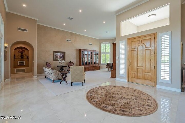 foyer featuring arched walkways, visible vents, recessed lighting, and ornamental molding