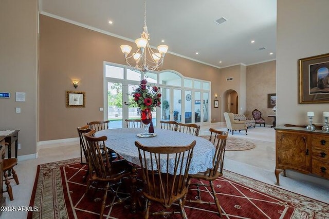 dining space with visible vents, arched walkways, a high ceiling, and ornamental molding