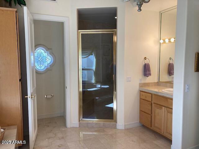 bathroom with baseboards, marble finish floor, a stall shower, and vanity