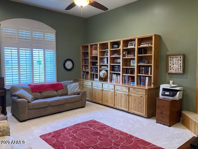 living room featuring light colored carpet and a ceiling fan