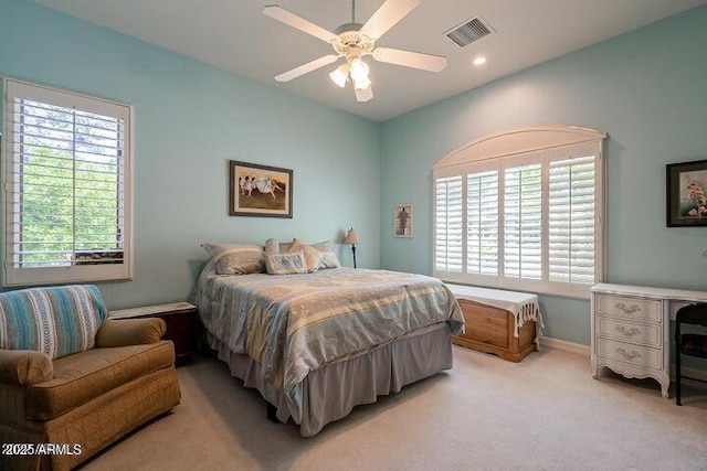 bedroom featuring visible vents, multiple windows, light carpet, and a ceiling fan