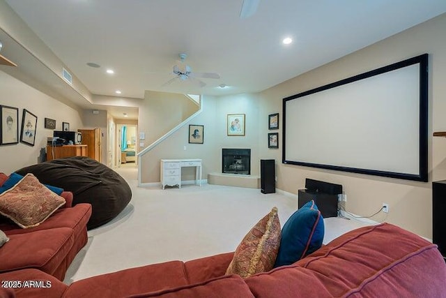 carpeted cinema room with visible vents, recessed lighting, baseboards, and a glass covered fireplace