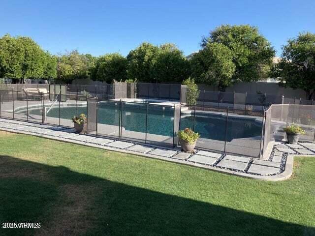 view of pool featuring a patio, fence, a fenced in pool, and a lawn