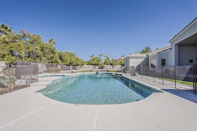 view of pool featuring a patio, a pool with connected hot tub, and a fenced backyard