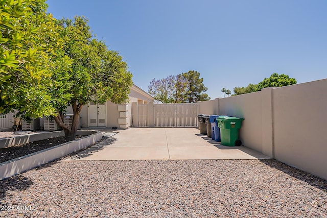 view of yard featuring a gate, fence, and a patio area