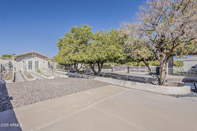 view of front of house featuring french doors, a patio, and fence