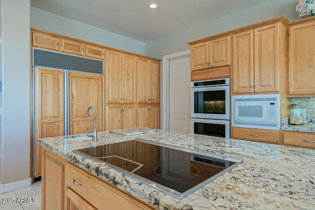 kitchen featuring white microwave, tasteful backsplash, double oven, light stone counters, and black electric cooktop