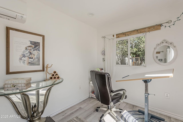 office space with light wood-type flooring, baseboards, and a wall mounted AC