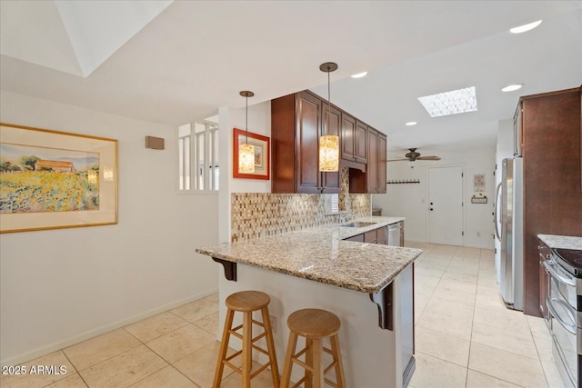 2313 S Grandview Ave, Tempe, AZ 85282 - kitchen with appliances with stainless steel finishes, a skylight, a peninsula, a sink, and light tile patterned flooring