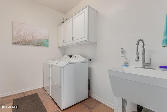 washroom featuring cabinets, sink, washer and dryer, and light tile patterned flooring