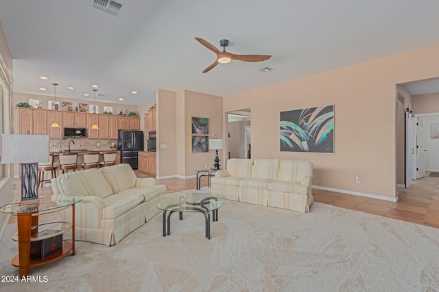 tiled living room with ceiling fan, sink, and a barn door