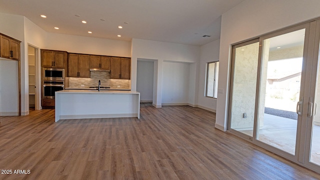 kitchen with plenty of natural light, backsplash, appliances with stainless steel finishes, and light countertops