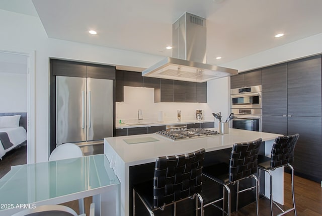 200 W Portland St Unit 1024, Phoenix, AZ 85003 - kitchen with island range hood, appliances with stainless steel finishes, a sink, a breakfast bar, and light countertops