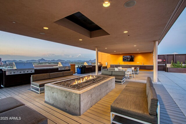 200 W Portland St Unit 1024, Phoenix, AZ 85003 - deck at dusk with an outdoor kitchen, an outdoor living space with a fire pit, and a patio