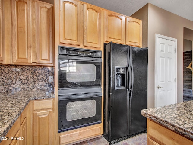 kitchen with backsplash, black appliances, dark stone countertops, and light brown cabinetry