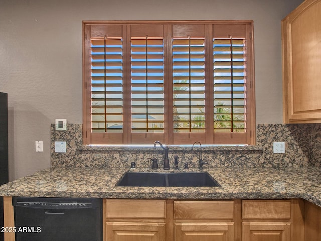kitchen with a sink, black dishwasher, and tasteful backsplash