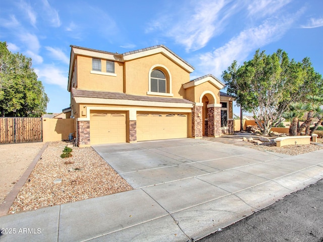 view of front of property featuring stone siding, fence, a garage, stucco siding, and driveway