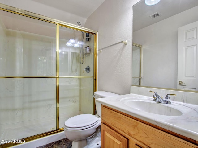 full bath with toilet, vanity, a shower stall, visible vents, and a textured wall