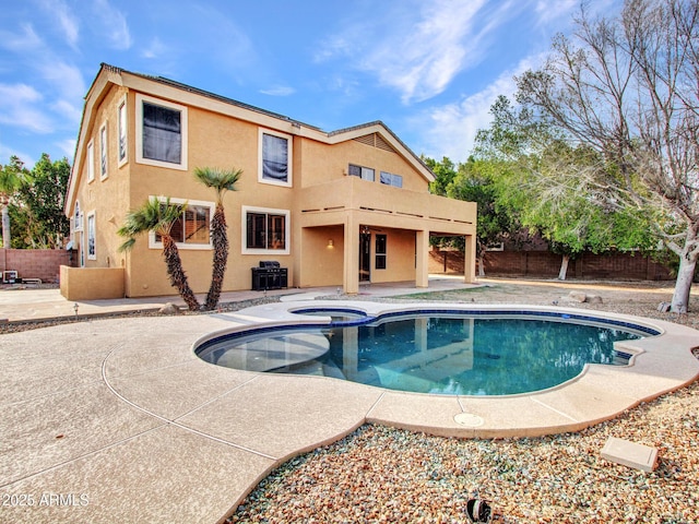 view of pool featuring a fenced backyard, a pool with connected hot tub, and a patio