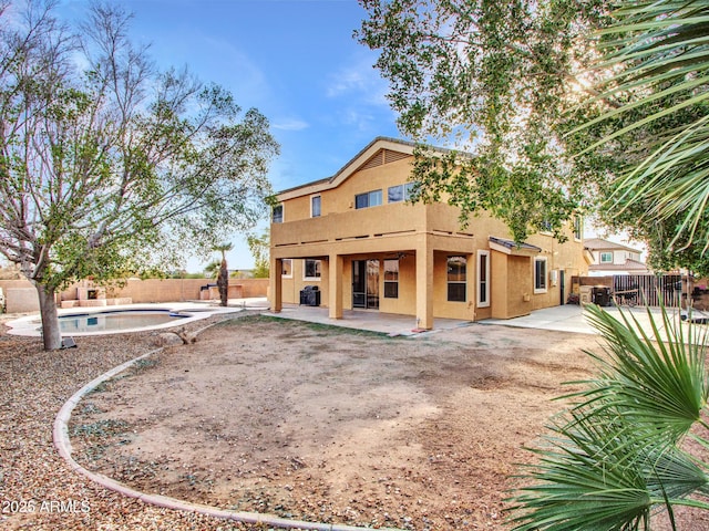 rear view of property with a fenced backyard, stucco siding, a patio area, and a fenced in pool