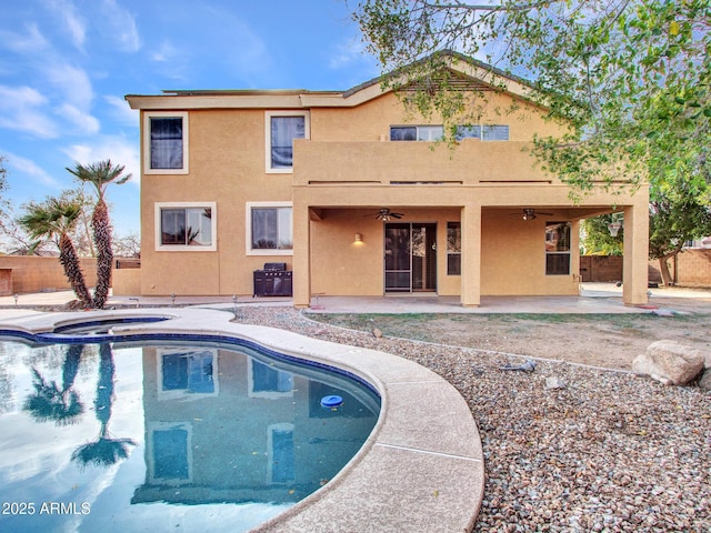 view of swimming pool with a ceiling fan, an in ground hot tub, fence, and a patio area