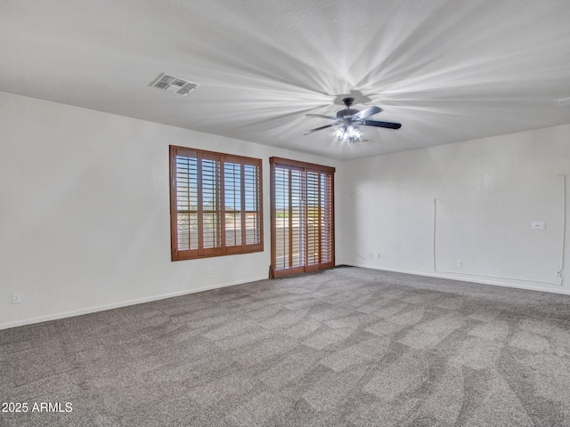 carpeted empty room featuring baseboards, ceiling fan, and visible vents