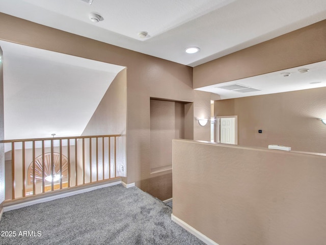 corridor featuring baseboards, carpet floors, and visible vents