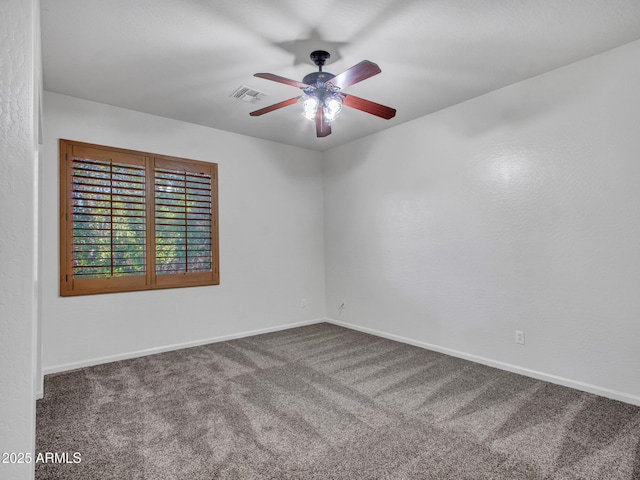 carpeted empty room with baseboards, visible vents, and a ceiling fan