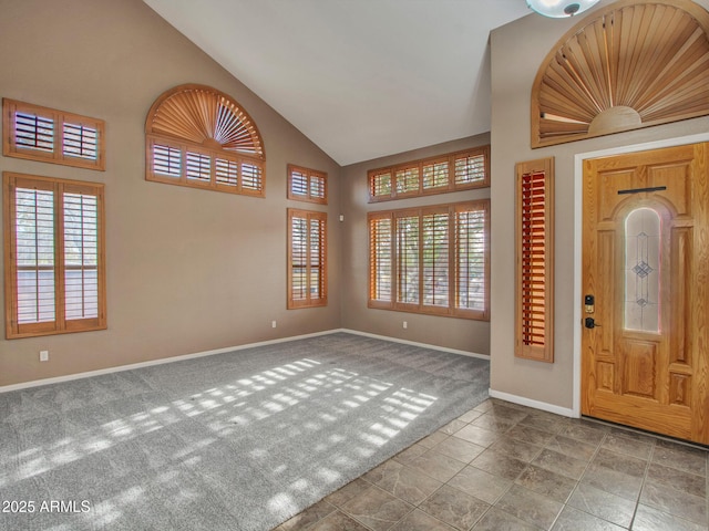 carpeted entrance foyer featuring high vaulted ceiling and baseboards