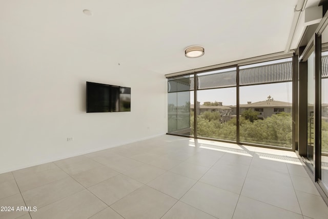 7120 E Kierland Blvd Unit 316, Scottsdale, AZ 85254 - tiled spare room featuring a wall of windows, plenty of natural light, and baseboards